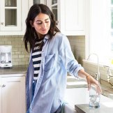 woman in kitche with glass of water woman in kitche with glass of water