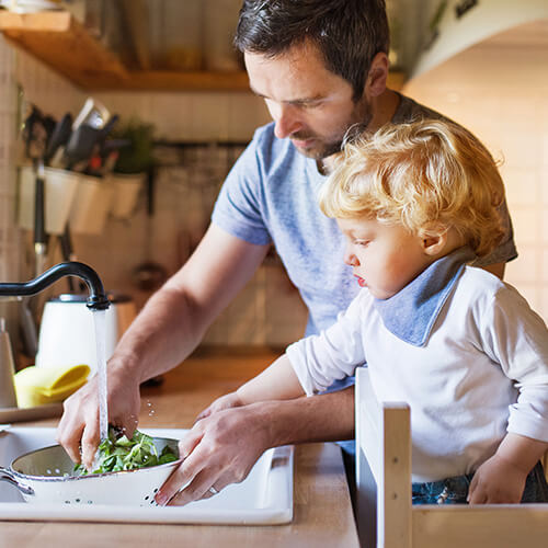 dad and son rinsing vegetables