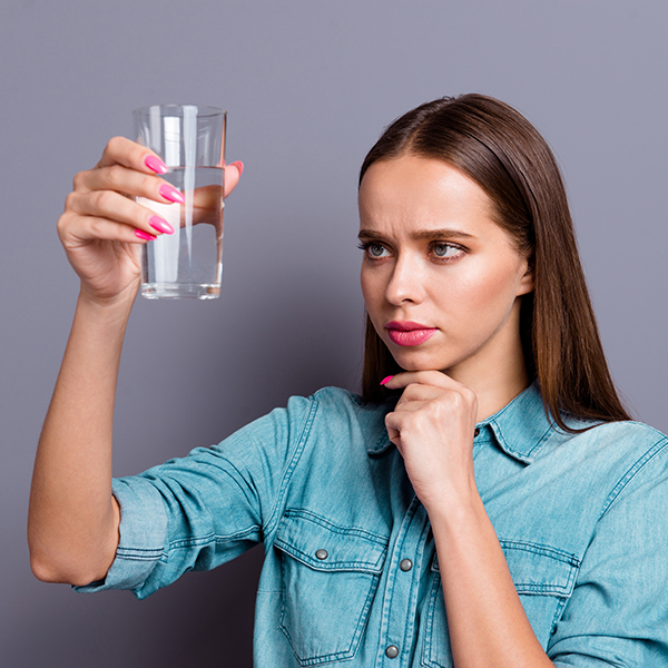 woman looking at glass of water